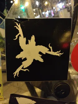 A sticker featuring a stylized, monochromatic illustration of a bird with sharp claws, set against a black background. The bird's design is somewhat abstract and evokes a sense of movement and aggression. The sticker is applied to a transparent surface, possibly glass or plastic.