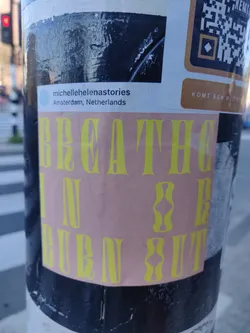 A peach-colored sticker with yellow text reading "Breathe in & Burn out". There is also a small Instagram sticker on top of it with the username "michellehelenastories" and location Amsterdam, Netherlands. 