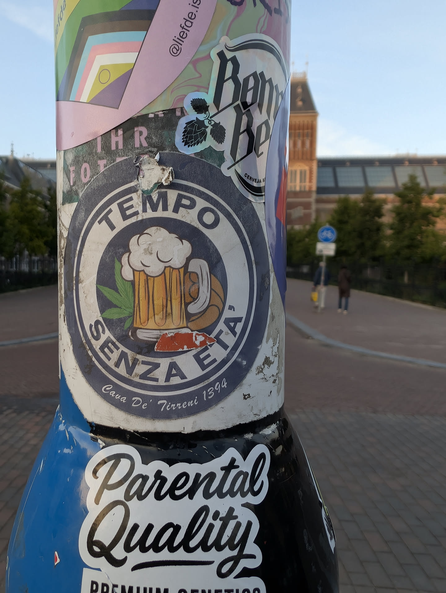 Circular sticker with a blue border. Features a central illustration of a foaming beer mug, a green cannabis leaf, and a basketball. Text reads 'TEMPO SENZA ETA'' and 'Cava De' Tirreni 1394'.