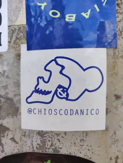 Street sticker A minimalistic sticker featuring a blue line drawing of a skull with an anchor on its side. The artist's Instagram handle is printed beneath the design. The sticker is affixed to a textured, off-white surface.