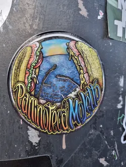Street sticker A round sticker featuring an illustration of two large sandwiches flanking a stylized seascape. The name "Paninoteca Moletto" is prominently displayed in colorful lettering.