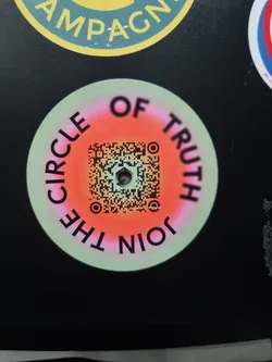 Round sticker with a QR code in the center. The text "Join the Circle of Truth" is written around the QR code. The background is light green with a red-pink gradient circle behind the QR code.