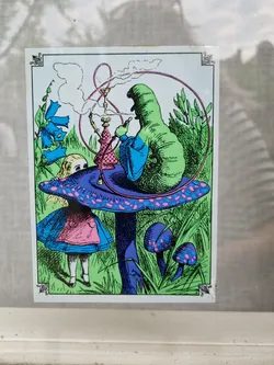 This sticker depicts a vibrant, psychedelic reimagining of Alice's encounter with the Caterpillar from Alice's Adventures in Wonderland. Alice is seen standing beneath the mushroom, while the Caterpillar sits atop it, smoking a hookah. The colors are bright and bold, with a neon-like quality.