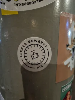 Street sticker A round sticker with a thumbs up symbol inside a circular design. The text "Lekker Gewerkt" which translates from Dutch to "Well Done" is written around the circle. At the bottom, it says PIK. 