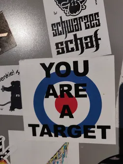 Street sticker A sticker with a target graphic and the text "YOU ARE A TARGET" printed on it. The target is blue, white and red.
