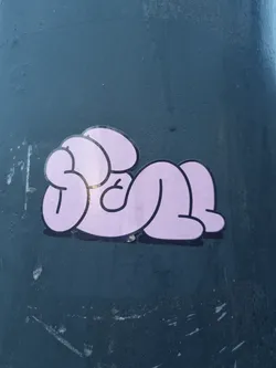 Street sticker A sticker of a pink figure in a laying position. The character is depicted in a simple, cartoonish style with rounded shapes and minimal details.
