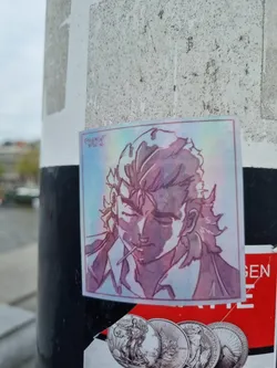 Street sticker A holographic sticker featuring a stylized portrait of a man with long hair. The art style is reminiscent of anime or manga, with a focus on shading and linework.  The colors are predominantly purples and pinks, with a subtle holographic effect.