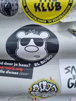 Street sticker Black and white sticker of a bear wearing sunglasses. The text 'EL BOSO' is written below the bear. The sticker has a minimalist design and is quite stylish.