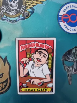 A sticker featuring a cartoon illustration of a boy with exaggerated features, possibly high, using what appears to be a tube of ointment or glue. The sticker has a red background with the text "Fucked Up Blind Kid" at the top and "High Guy" at the bottom. The style is reminiscent of vintage skateboarding graphics.