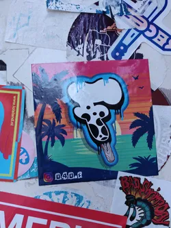 Street sticker A sticker featuring a stylized ice cream design with a drip effect. The background is a sunset scene with palm trees.  The Instagram handle @040.f is visible on the sticker.