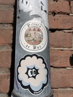 Street sticker The sticker is a stylized cartoon of a cloud with two large, oval eyes expressing surprise. The cloud has a pale blue and white fill with a thick black outline. Below the cloud is the text "@DROOWLEN".