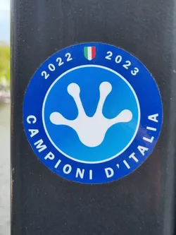 Street sticker A blue circular sticker with a white gecko footprint in the center.  The text "CAMPIONI D'ITALIA" is written around the footprint. The years 2022 and 2023 are written on the top, with an Italian flag in the middle.