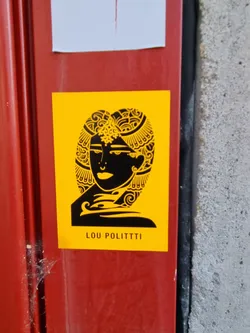 Street sticker Yellow sticker with a black illustration of a woman's face adorned with intricate headwear. The artist's name, LOU POLITTI, is printed at the bottom. 