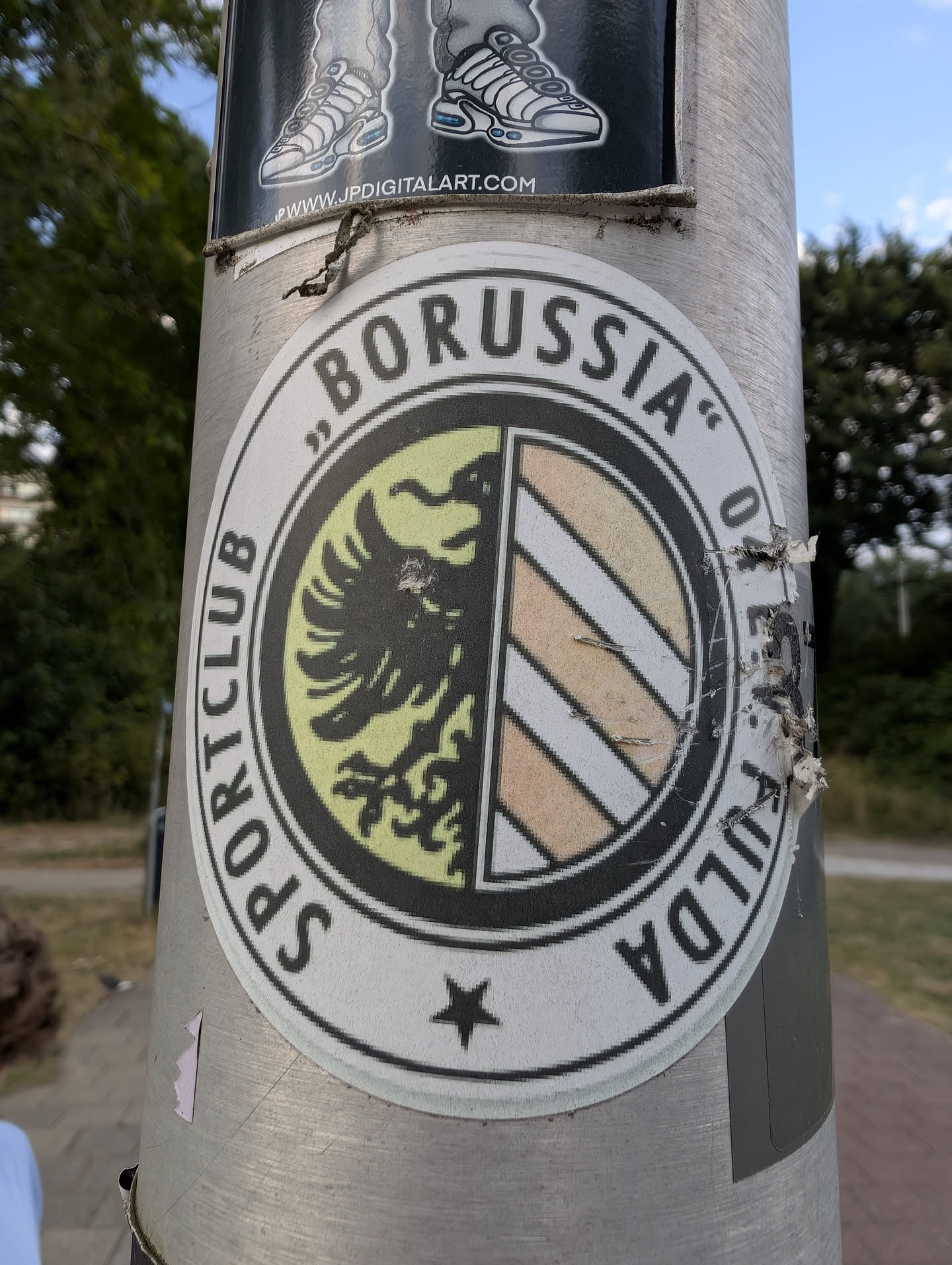 A round sticker displaying the SC Borussia Fulda logo. It features a split inner shield with a black eagle on the left and diagonal stripes on the right, surrounded by the club's name in black text.