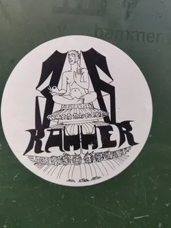 Street sticker This round sticker showcases a striking black and white illustration. A figure sits cross-legged on a platform, possibly a throne or altar, surrounded by intricate detailing and what looks like a symbolic border. The word "RAWLER" is prominently displayed in stylized lettering below the figure, adding to the mysterious and artistic appeal of this sticker.