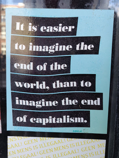 Street sticker A sticker with a quote about the ease of imagining the end of the world versus the end of capitalism. The text is in black and white with a light blue background.  A website address is present at the bottom.