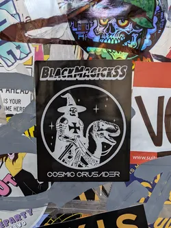 Street sticker A black and white sticker featuring a knight riding a dinosaur, with the text "BlackMagickss" at the top and "Cosmic Crusader" at the bottom. The design is enclosed in a circle.