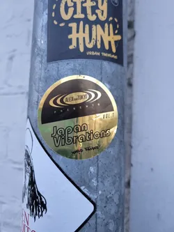 Street sticker Gold sticker with the text "Japan Vibrations" and the logo of Alex from Tokyo. It indicates it is volume 1 of a series.