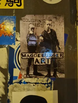 Street sticker A sticker featuring a black and white photo of two boys, possibly in the style of 80s punk or new wave. Text on the sticker says 'Magdeburg Art' and 'Hooligans '85'.