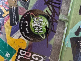 Round sticker with a green planet and the text Planet Blunt and Seit 1995. There is also a website and a phone number.