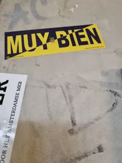 Street sticker A yellow and dark blue sticker with the words "MUY BIEN" (Spanish for "Very Good") in a bold sans-serif font. A small bee illustration separates the words. The sticker includes a social media handle (@muybienstickers) and a website URL (https://www.muybienstickers.com).