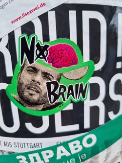 Street sticker A sticker with a graphic of a man's face wearing a cap with a brain on it. The text 'No Brain' is written on the sticker.  The style is reminiscent of punk or protest art.
