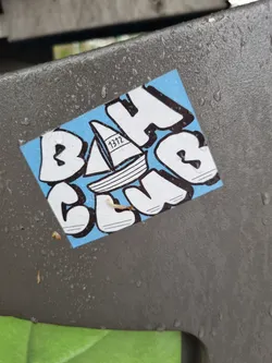 A light blue sticker with the words BAH CLUB in a stylized graffiti font. A small sailboat is featured in the center. The number 1312 is visible on the sail.