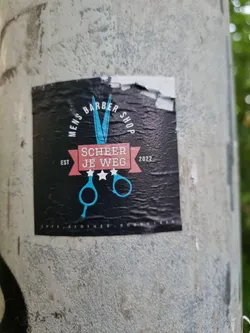 Street sticker Black sticker with a pair of scissors and text. The text includes 'Mens Barber Shop', 'Scheer Je Weg', 'Est 2022', and 'coots, clothes, goodies'.