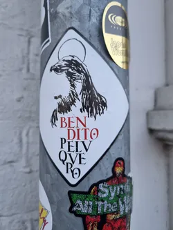 Street sticker A sticker featuring a stylized image of Jesus with the text "BEN DITO PELV QVE RO" which translates from Latin to "Blessed are the peacemakers".
