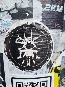 Street sticker A round black and white sticker with the text "limits.fm" repeating around the edge.  The central image depicts a person sitting with multiple pairs of arms reaching outward. The style is dark and slightly unsettling.