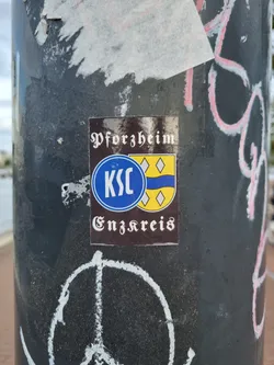 A brown sticker with the text "Pforzheim" at the top, a logo in the middle that appears to be a circular emblem with the letters KSC and a yellow and blue shield, and the text "Enzkreis" at the bottom.