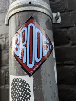 Street sticker A diamond-shaped sticker with a black border, featuring the stylized word 'BROOS' in light blue bubble letters on a red background. Includes a small Instagram handle along the bottom right edge.