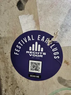 Street sticker Purple round sticker with the text "Festival Earplugs" written in a circle around a logo and a QR code. Below the QR code it says "Scan me". The logo shows five stylized mountains with the text "Rechts voor" and "Est 2023" underneath.