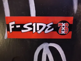 Street sticker A red and black sticker with the text "F-SIDE" in a stylized font and the number "76" enclosed in a circle with cross markings. The sticker has a horizontal stripe design.