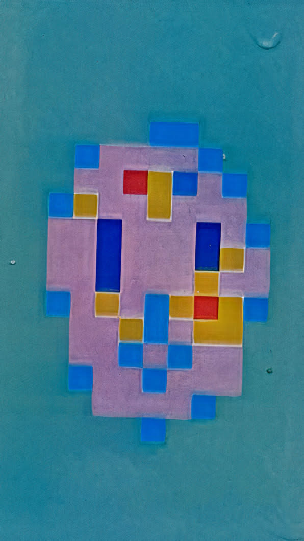The sticker features a pixelated design reminiscent of a Space Invader, rendered in shades of light purple, blue, red, and yellow. It has a geometric, retro aesthetic, with a simple and stylized shape.