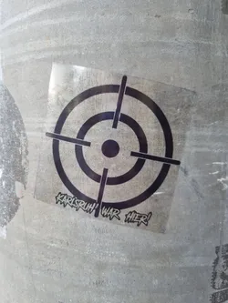 A black and white sticker with a target graphic and the text 'Karlsruhe war hier!' (Karlsruhe was here!).