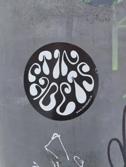A round black and white sticker with an abstract design. The design features white organic shapes on a black background.  The text at the bottom reads 'www.tincabels.tk'.