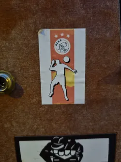 A sticker featuring the logo of AFC Ajax, a Dutch football club, and a stylized silhouette of a player.
