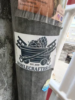 Street sticker A white sticker depicting a dark blue mining cart loaded with hops. A shovel rests diagonally across the front, flanked by two ladders. The text 'EST. 2019' and 'KOHLECRAFTBRÄU' is printed below.