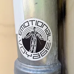 Street sticker Black and white circular sticker featuring a robotic figure at the center with the words "Emotional Voyage" written around it. The figure has its arms outstretched, and appears to be radiating light. The text is stylized in a geometric font.