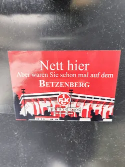 Street sticker A red sticker with a picture of the Betzenberg stadium and the text "Nice here, but have you ever been to the Betzenberg?" in German. The sticker also features the logo of 1. FC Kaiserslautern.