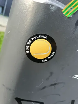 Street sticker A black and yellow circular sticker featuring a tennis ball graphic and the text 'BSG BA Neukölln Abt. Tennis'.