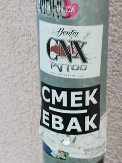 Street sticker Black and white sticker with the text CMEK above a line and EBAB below.  It's stuck on a pole with other stickers, one of which is an advertisement for CNX Tattoo in Berkely. 