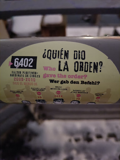 Street sticker &iquest;QUI&Eacute;N DIO 6402 Who LA ORDEN? FALSOS POSITIVOS= ASESINATO DE CIVILES gave the order? 2000-2010 Wer gab den Befehl? BAJO EL MANDO DE MARIC MONTUYA CRIBE ADOLFU LEON NICACIO DE HEHNANDEZ JEBUS MARTINCZ MARCOS JUAN CARLOS PINTO BAPPERA 2429 75 39 45 154