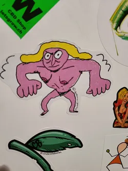 Street sticker A sticker featuring a cartoon-like illustration of a muscular pink-skinned figure with blonde hair. The character has a somewhat angry expression and is depicted in a slightly aggressive pose. The art style is reminiscent of crude drawings or doodles, with bold outlines and simple shading.  The sticker is likely from an independent artist or brand.