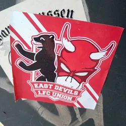 Street sticker A red and black sticker featuring a bear and a devil's head, with the text "East Devils 1.FC Union" on a banner. The sticker likely represents a fan club or supporter group for the German football club 1. FC Union Berlin.