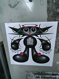 Street sticker The sticker features a unique cartoonish character rendered in black and white with touches of red and blue. The character has a round body, large eyes with a red halo above, and horns that appear like sharp curves. The limbs are bulbous and adorned with circles resembling beads. A QR code is placed on the character's body. The style is reminiscent of surrealist art.