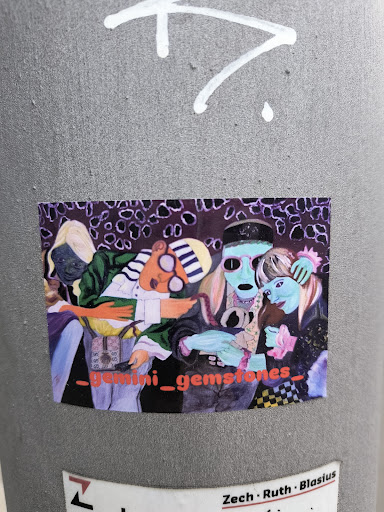 The sticker features a group of stylized characters in a colorful setting. A blond character on the left wears a purple robe and what appears to be some sort of mask. Another character wears a black and white striped hat and strange glasses. There's a tall character in the center with a greenish-blue face, wearing a black hat. A character on the right with blue skin holds pink flowers. The background is dark with a pattern of purple circles. The words '_gemini_gemstones_' are written across the bottom of the sticker. The style is artistic and illustrative.