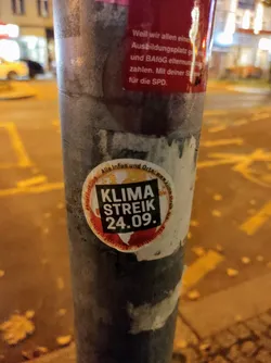 A sticker on a pole advertising a climate strike on September 24th.