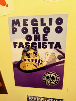 Street sticker The sticker features a cartoon pig character, reminiscent of Porco Rosso, depicted from the chest up, wearing aviator goggles with purple lenses, a brown pilot's helmet, and a white and purple striped scarf. The pig has a prominent mustache and is shown giving a thumbs-up with a white-gloved hand, seemingly driving a purple open-top car. On the pig's left arm, the number '161' is visible. The top portion of the sticker has large, bold, dark purple text against a lighter, almost white background, reading 'MEGLIO PORCO CHE FASCISTA'. In the bottom right corner, there's a circular black and white logo for 'TENNIS BORUSSIA BERLIN' featuring an eagle crest with a 'B' in the center. The overall color scheme is dominated by purple, white, and yellow/tan.